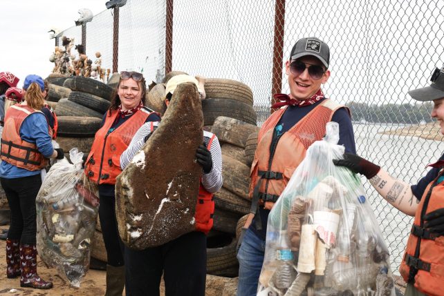 Illinois State volunteers pass trash down the line to pile at the end of the barge.