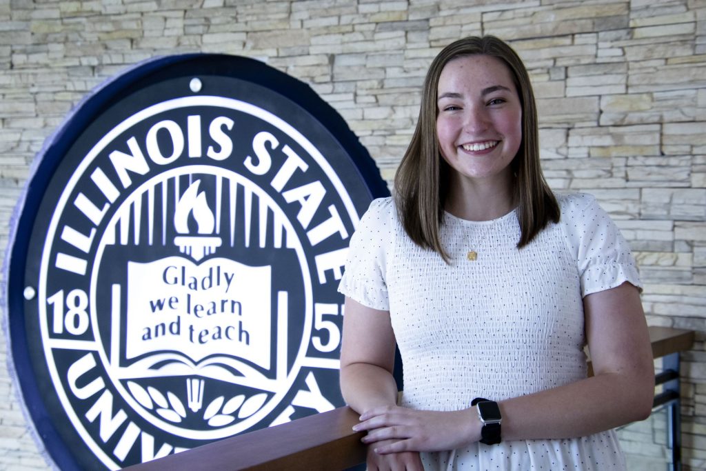Jenna Swingler smiling in front of ISU seal