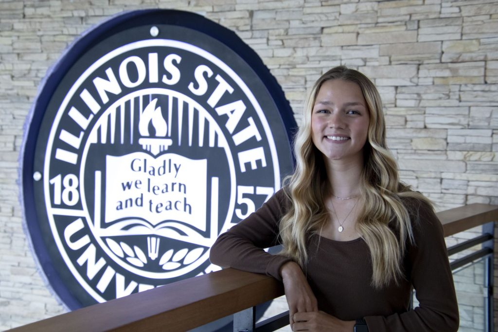 Natalie Garneau smiling in front of ISU seal