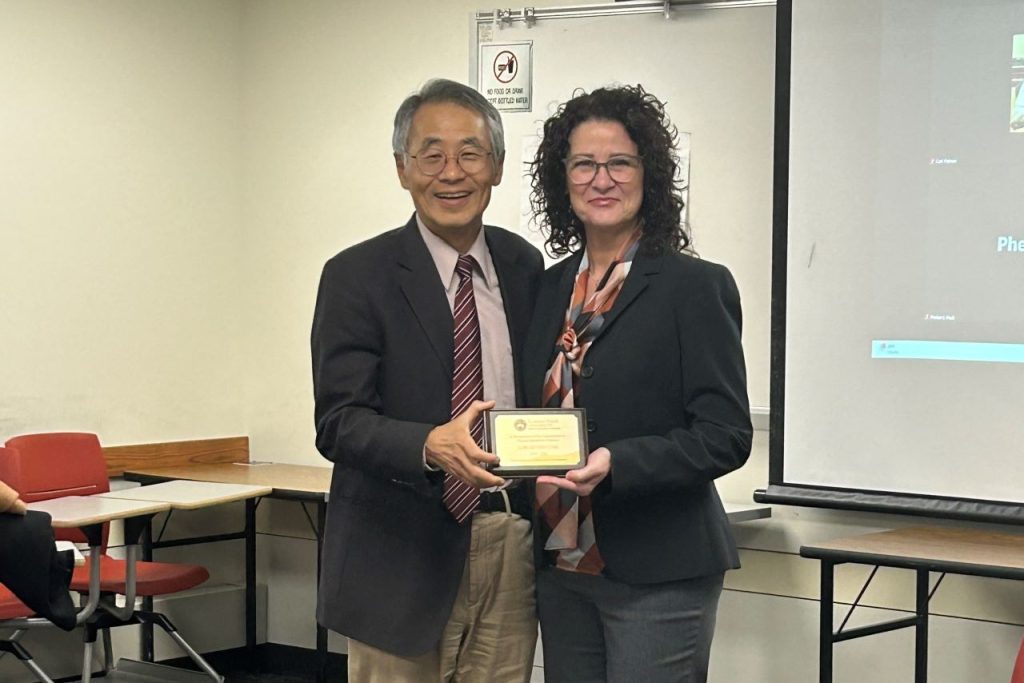 Dr. Riverstone and Dr. Wang standing next to each other with the award plaque