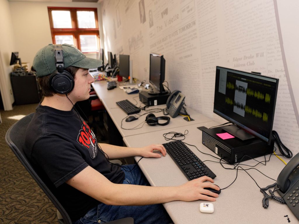 A student edits audio at a computer