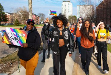 Participants march with hand signs and pride flags in the 2023 Transgender Day of Visibility Sashay.