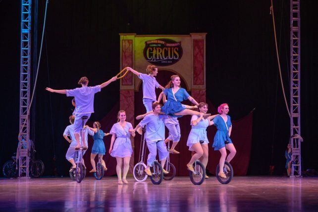 Gamma Phi Circus performers on unicycles during a show