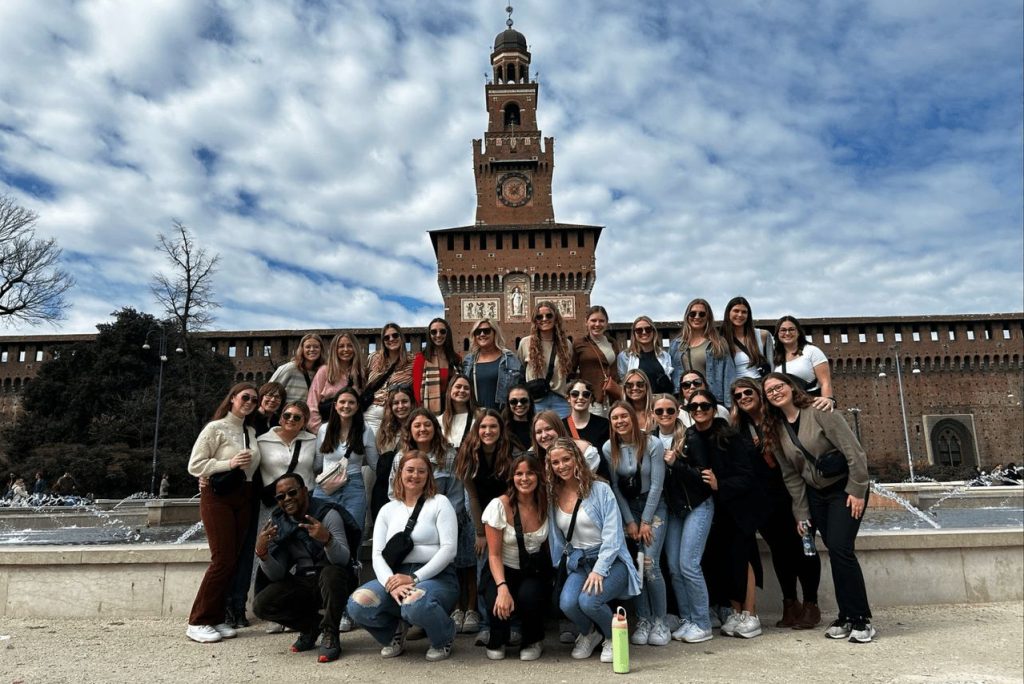 A group of CSD students stand together in fornt of a landmark during a study abroad trip