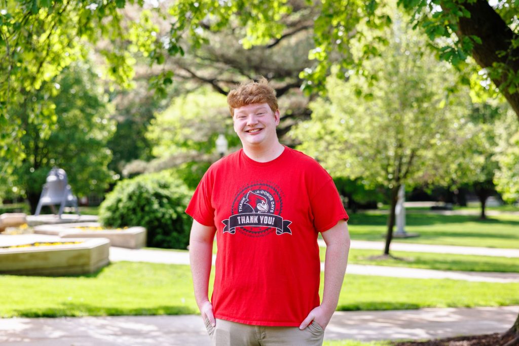 Student standing on the Quad wearing a red shirt