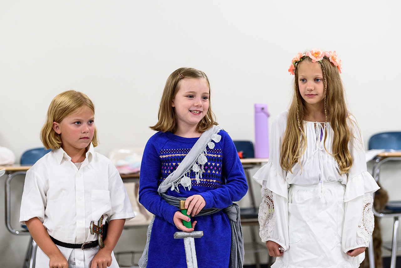 A group of students dressed in costume participate in a summer camp class