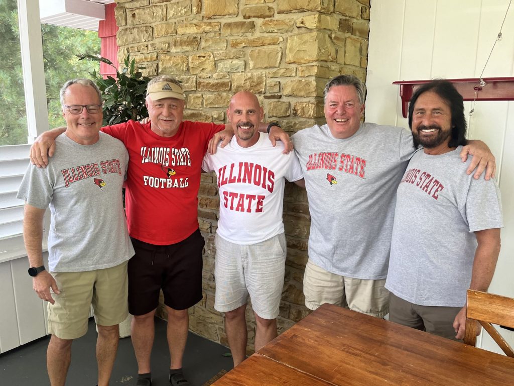 group of five people with arms around each other wearing Illinois State shirts