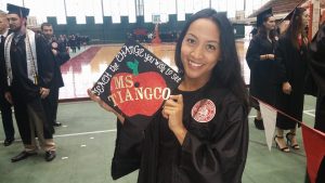 Student holds her mortarboard
