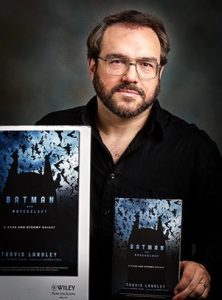 Travis Langley holding his book on the psychology of Batman