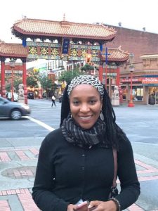 a woman standing in front of Chinatown, smiling