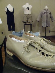 Bowling shoes from the 1930s with outfits on mannequins in the background