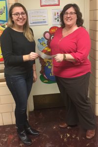 Student receives check from staff member