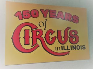 Yellow sign with red lettering that states "150 years of Circus in Illinois"