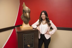 Sarah Aguilar standing by the Reggie bust in Hovey Hall.