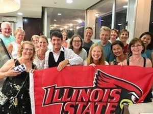 Communication Sciences and Disorders alumni in Italy holding an Illinois State University flag