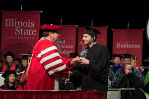 Sam Alex receives the Outstanding Young Alumni Award from Illinois State University President Larry Dietz at the 2019 Founders Day Convocation.