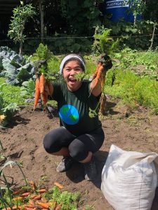 Student holding carrots and smiling