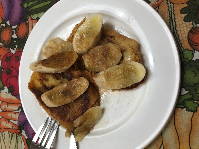 Breakfast consisting of toast and sliced banana's topped with brown sugar.