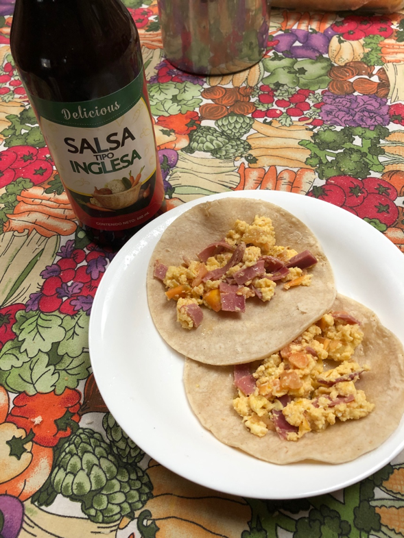 Breakfast containing two tortillas, eggs, ham and cheese along with "Salsa Tipo Inglesa".