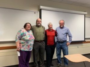 4 adults standing in a classroom