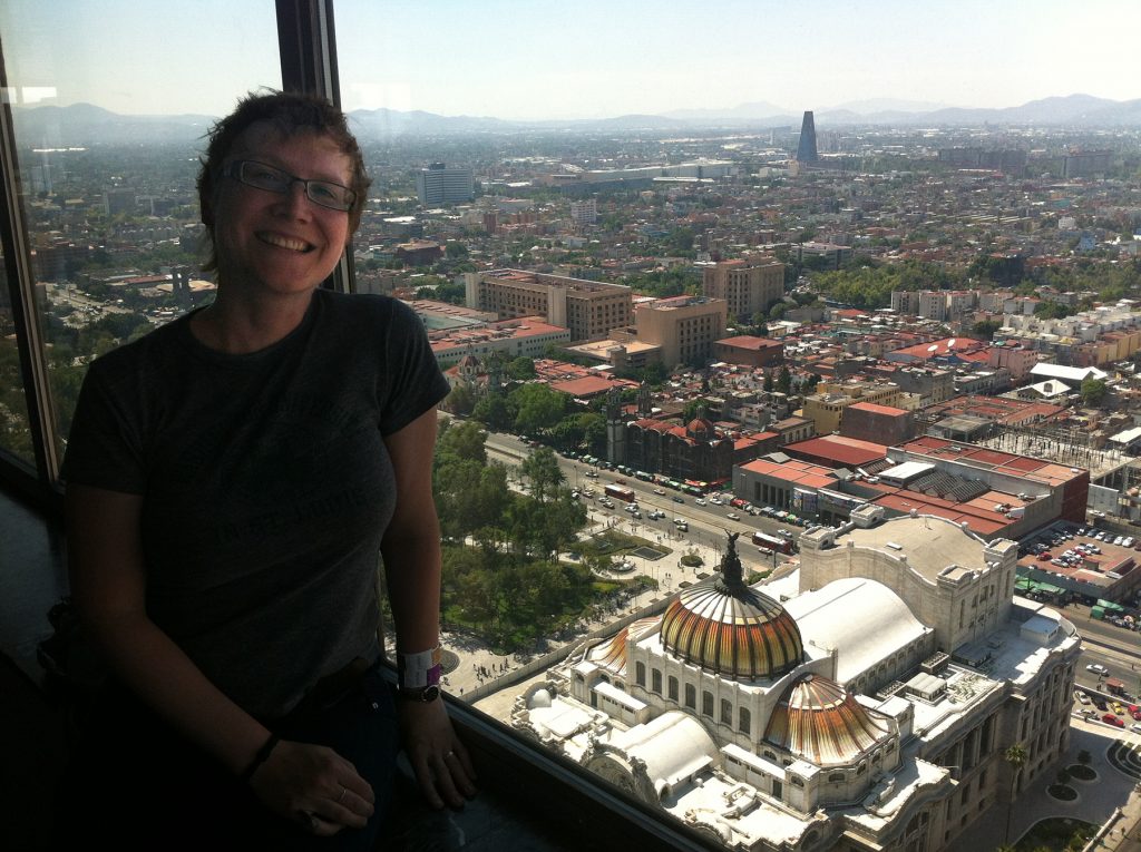 woman at a window with a view of Mexico City in the background