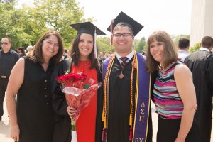 Illinois State students pose with parents at graduation