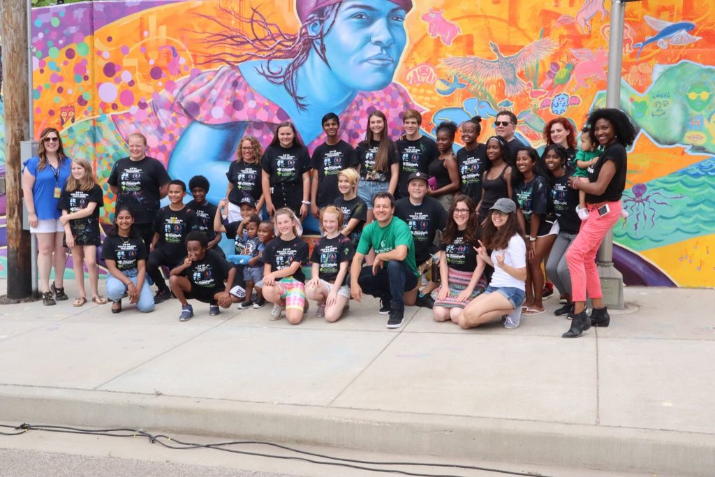 Students pose with mural.