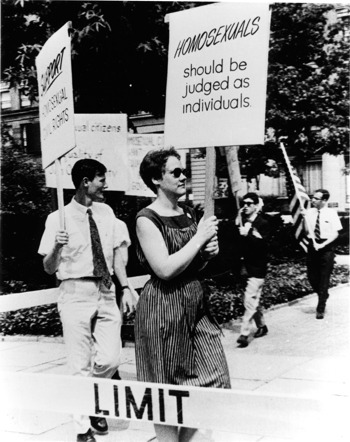 Barbara Gittings holding a protest sign that reads Homosexuals should be judged as individuals 