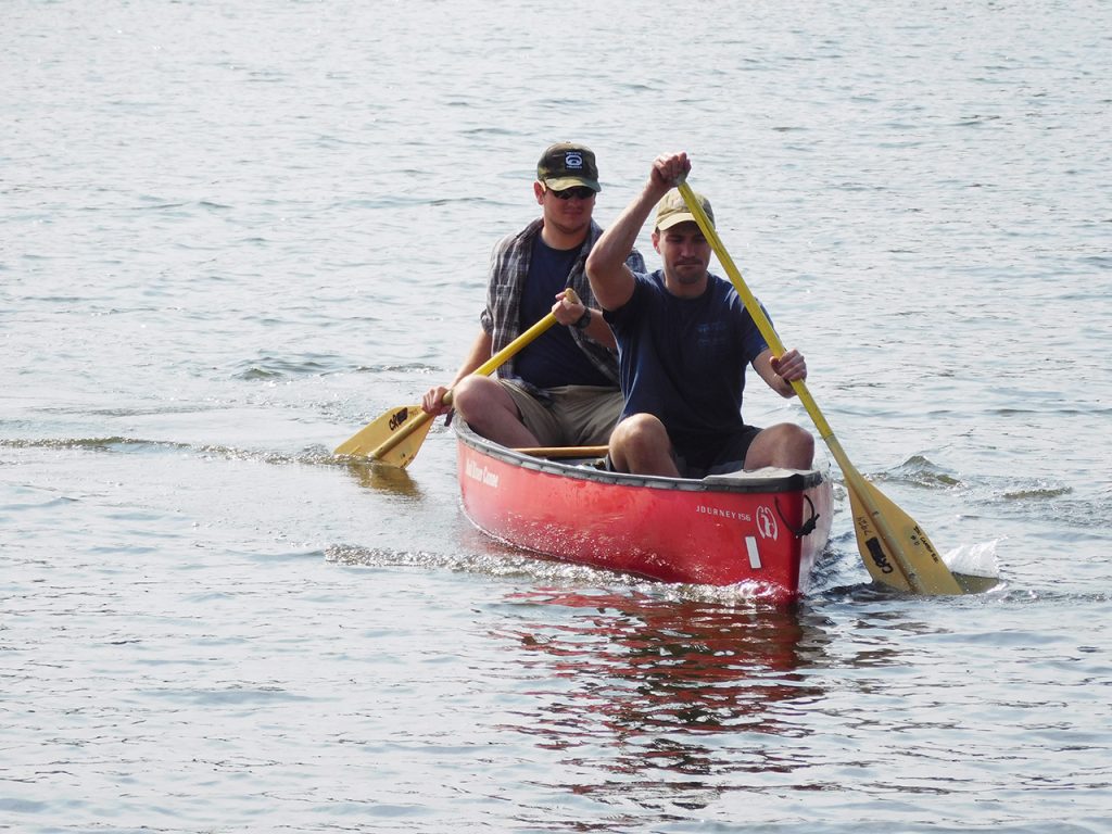 two men rowing in a canoe