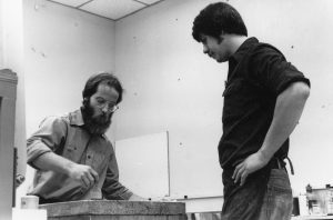 two artists working with a lithography stone on a press