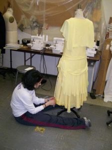 School of Theatre and Dance alumna Christina Leineke as a student working in the Costume Shop on a yellow dress for the production of MA RAINEY'S BLACK BOTTOM