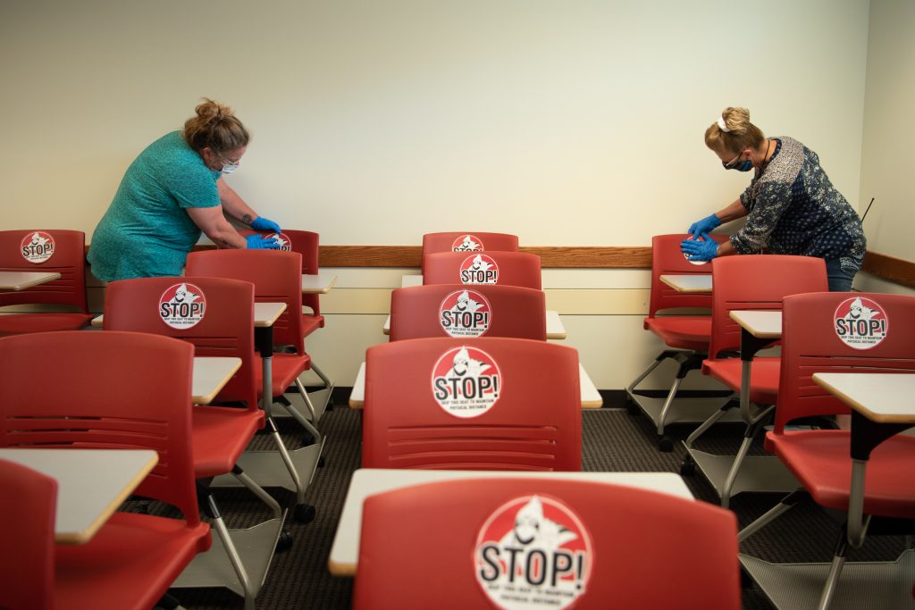 Workers place stickers on chairs