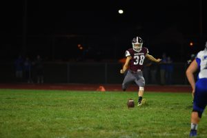 Sam Carroll kicks a football during a high school game