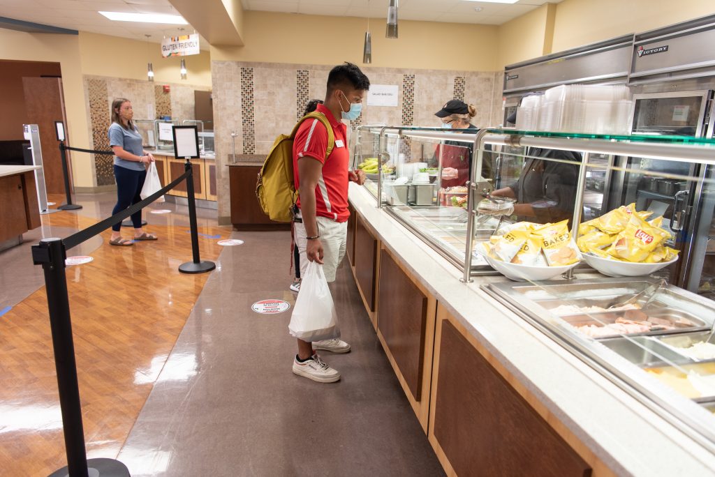 Micor waits for his food to be served into to-go containers at the Watterson Dining Commons.