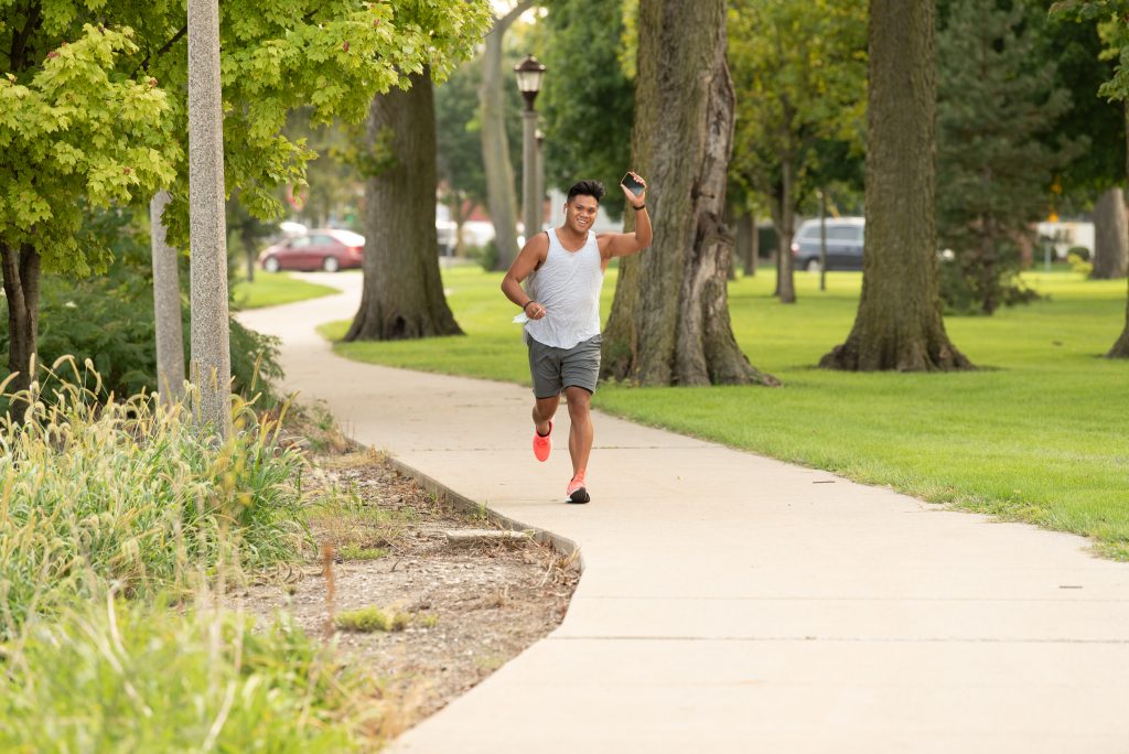 Micor waves to a friend as he runs through People’s Park on his two-mile run from his apartment to Watterson Towers.
