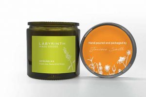 Green candle, Labyrinth Made Goods and one orange candle, hand poured and packaged by women at Labyrinth, a YWCA.